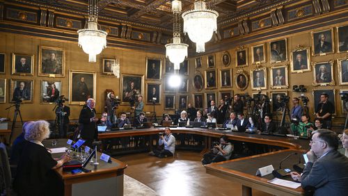 FILE - Mats Larsson, member of the Royal Academy of Sciences, standing at left, speaks during the announcement of the winner of the 2023 Nobel Prize in Physics, at the Royal Academy of Sciences, in Stockholm, on Oct. 3, 2023. (Anders Wiklund/TT News Agency via AP, File)