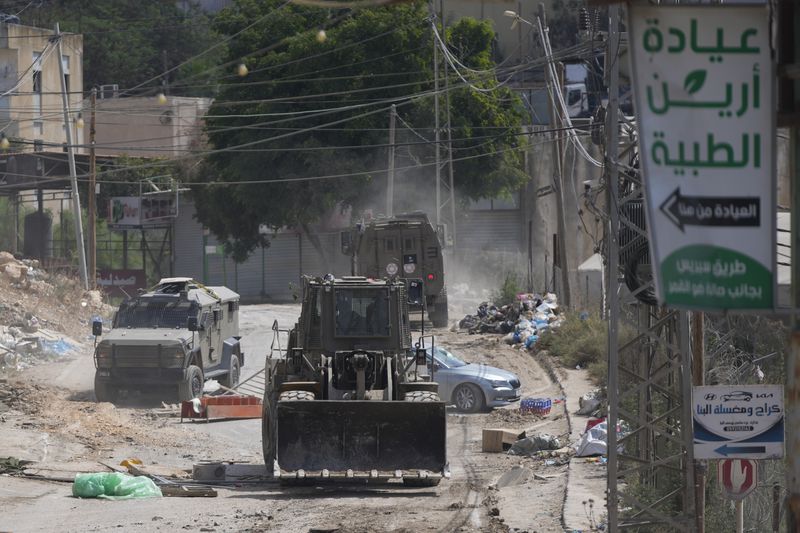 A bulldozer from the Israeli forces moves on a street during a military operation in the West Bank refugee camp of Al-Faraa, Wednesday, Aug. 28, 2024. (AP Photo/Nasser Nasser)