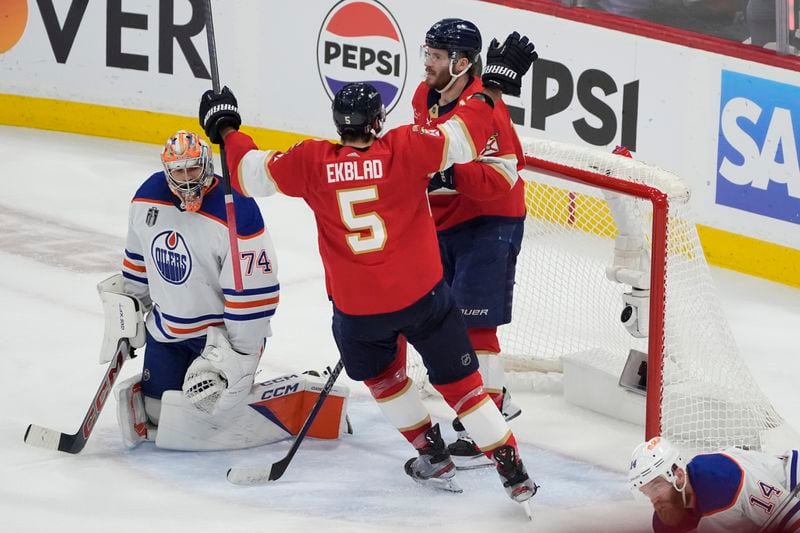 Florida Panthers defenseman Aaron Ekblad (5) congratulates left wing Matthew Tkachuk (19) after Tkachuk scored a goal against Edmonton Oilers goaltender Stuart Skinner (74) during the second period of Game 5 of the NHL hockey Stanley Cup Finals, Tuesday, June 18, 2024, in Sunrise, Fla. (AP Photo/Rebecca Blackwell)