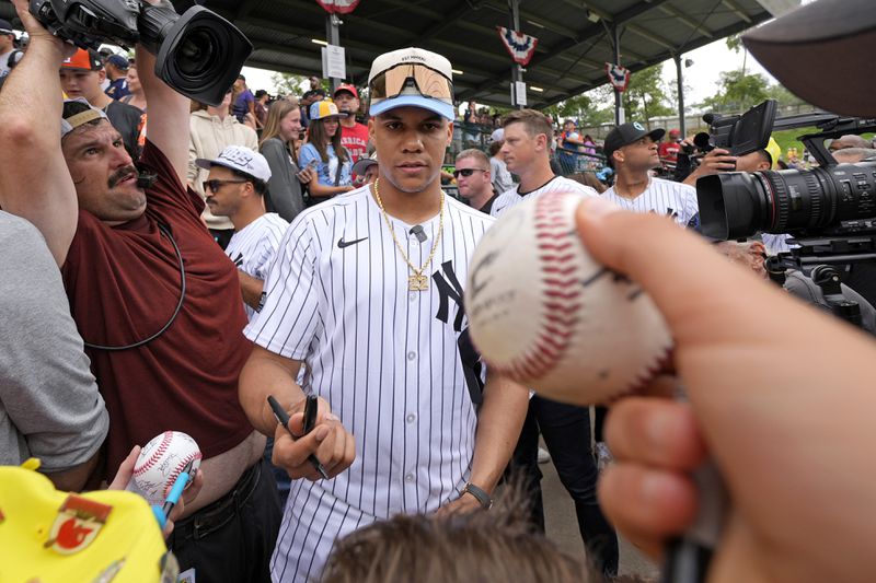 New York Yankees' Juan Soto, center, makes his way to his seat at Lamade Stadium during a team visit to the Little League World Series tournament in South Williamsport, Pa., Sunday, Aug. 18, 2024. The Yankees will be playing the Detroit Tigers in the Little League Classic at Bowman Stadium in Williamsport, Pa., on Sunday Night Baseball. (AP Photo/Gene J. Puskar)