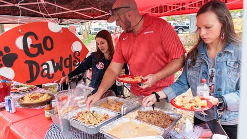 Rebecca Lovett, Josh Webb and Monica Moon eat lunch before the Georgia-Tennessee game Nov. 5 in Athens. (Arvin Temkar / arvin.temkar@ajc.com)