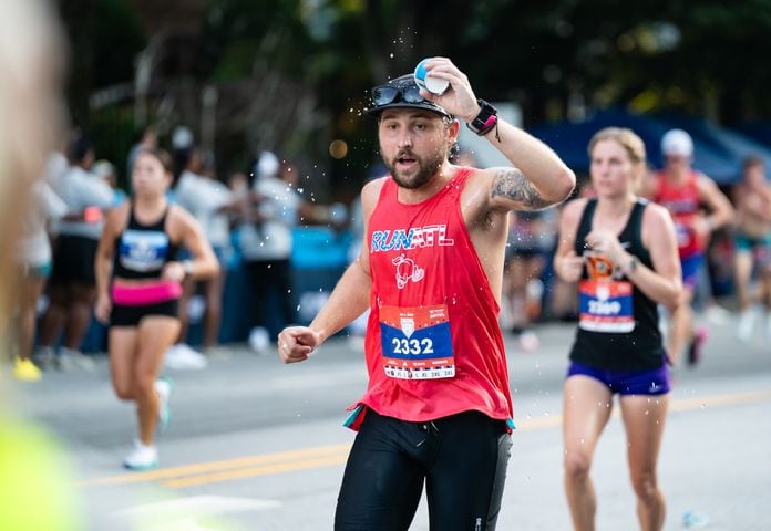 A runner dumps water on his head during the 55th running of The Atlanta Journal-Constitution Peachtree Road Race at "Cardiac Hill" on Peachtree Road NW in Atlanta on Thursday, July 4, 2024. (Seeger Gray / AJC)