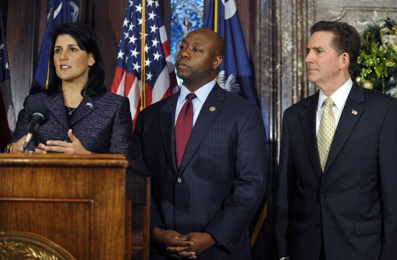 FILE - South Carolina Gov. Nikki Haley, from left, announces U.S. Rep. Tim Scott as the state's next U.S. senator as Sen. Jim DeMint looks on at the South Carolina Statehouse Dec. 17, 2012, in Columbia, S.C. Scott's life has been a series of people offering a hand that helped him get ahead. Now the senator from South Carolina waits to see if former President Donald Trump gives him another boost and makes him the vice presidential nominee. (AP Photo/Rainier Ehrhardt, File)