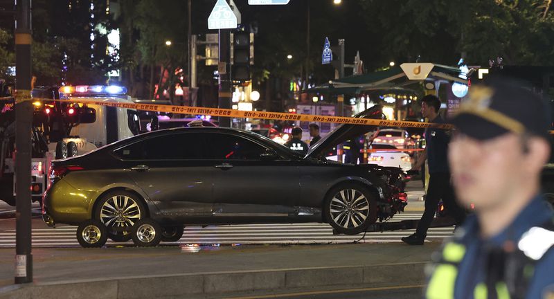 Police officers control a car accident scene near Seoul City Hall in downtown Seoul, South Korea, Monday, July 1, 2024. A car slammed into pedestrians in central Seoul on Monday night, killing nine people and injuring four others, officials said. (Seo Dae-yeon/Yonhap via AP)