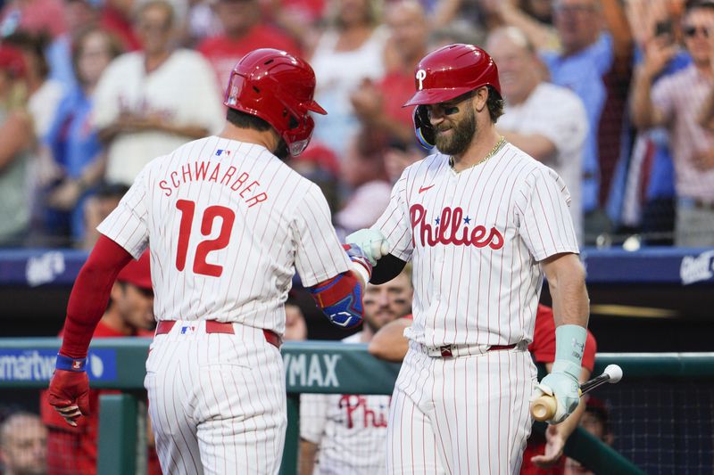 Philadelphia Phillies' Kyle Schwarber (12) celebrates his solo home run with Bryce Harper during the first inning of a baseball game against the Tampa Bay Rays, Tuesday, Sept. 10, 2024, in Philadelphia. (AP Photo/Derik Hamilton)