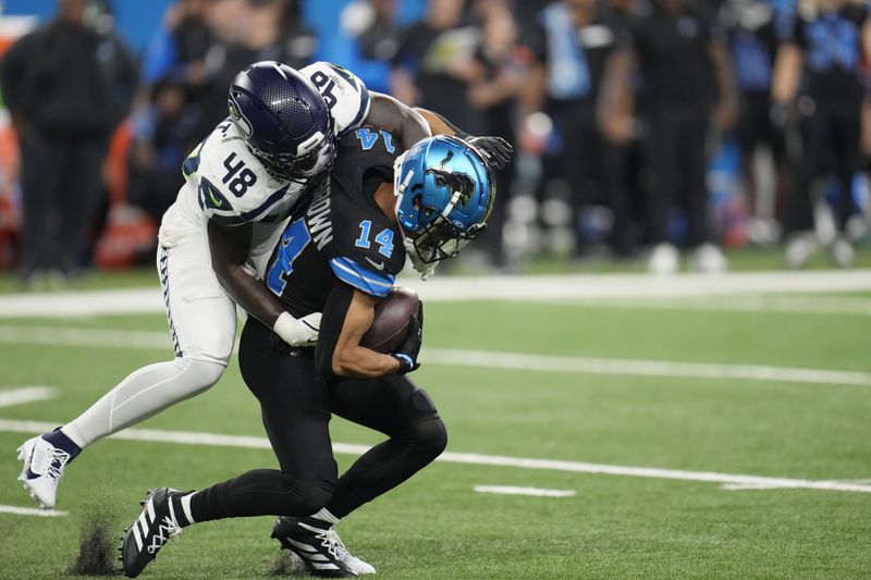 Detroit Lions wide receiver Amon-Ra St. Brown (14) is tackled by Seattle Seahawks linebacker Tyrice Knight (48) during the first half of an NFL football game, Monday, Sept. 30, 2024, in Detroit. (AP Photo/Paul Sancya)