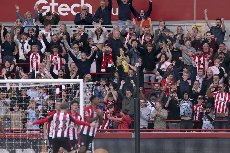 Brentford fans celebrate their side's fourth goal of the game scored by Ethan Pinnock during the Premier League match between Brentford and Wolverhampton at the Gtech Community Stadium, London, Saturday Oct. 5, 2024. (Steven Paston/PA via AP)