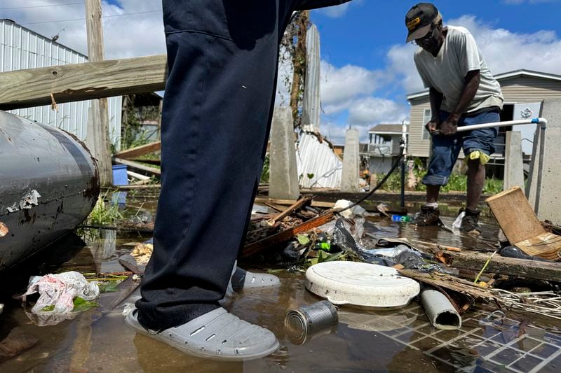 Brothers Wilson Garner, 73, left, and Carter Caldwell, 69, try to fix a broken water pipe, Thursday, Sept. 12, 2024, in Ashland, La., in the aftermath of Hurricane Francine. (AP Photo/Jack Brook)