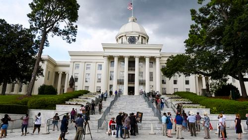 FILE - In this July 26, 2020, file photo, people gathered near the Alabama Capitol in Montgomery, Ala. (AP Photo/Julie Bennett, File)