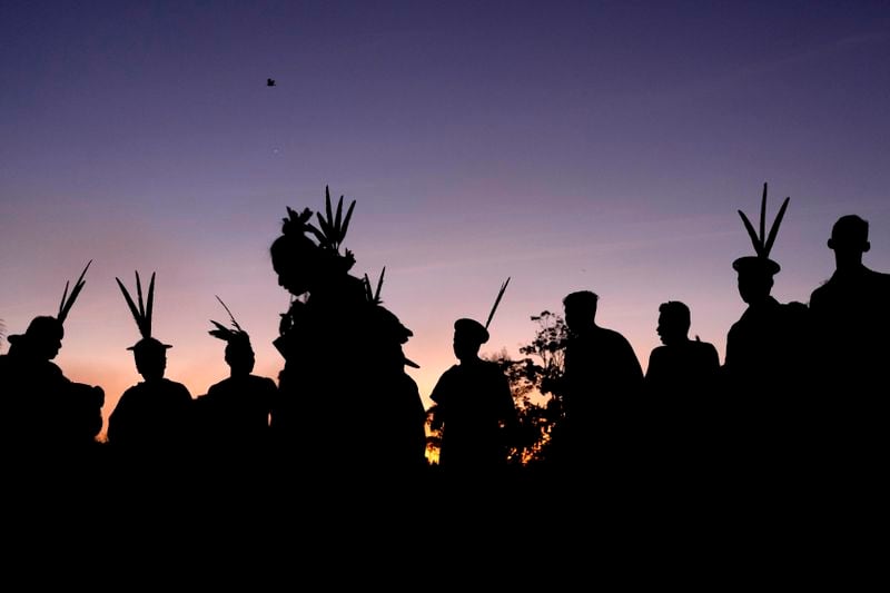 Ashaninka Indigenous people from Brazil and Peru dance and sing at dawn during the annual celebration recognizing the Ashaninka territory in the Apiwtxa village, Acre state, Brazil, Monday, June 24, 2024. (AP Photo/Jorge Saenz)