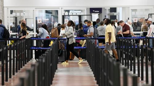People pass through a security checkpoint entrance at the Hartsfield-Jackson International Airport on Thursday, May 26, 2022. Miguel Martinez / miguel.martinezjimenez@ajc.com