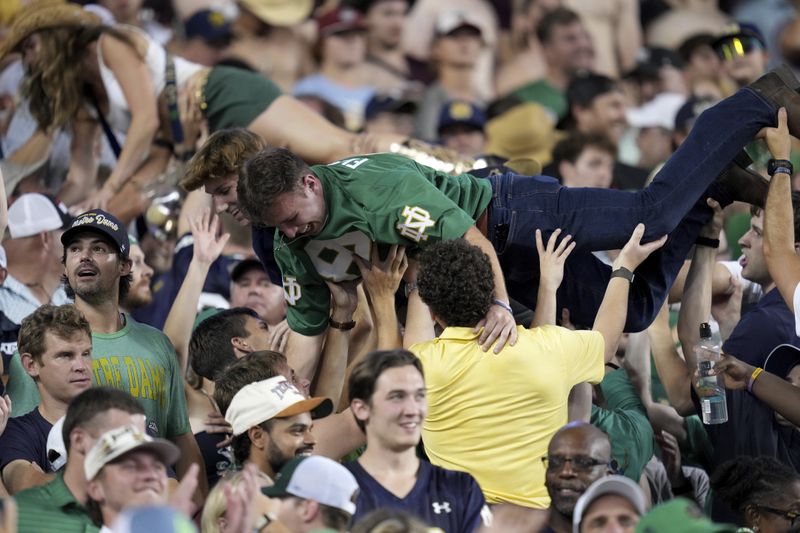 Notre Dame fans celebrate after the team scored a touchdown against Texas A&M during the fourth quarter of an NCAA college football game Saturday, Aug. 31, 2024, in College Station, Texas. (AP Photo/Sam Craft)