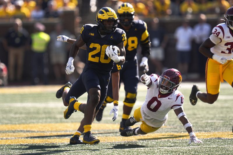 Michigan running back Kalel Mullings (20) runs for a 53-yard touchdown as Southern California safety Akili Arnold (0) defends in the first half of an NCAA college football game in Ann Arbor, Mich., Saturday, Sept. 21, 2024. (AP Photo/Paul Sancya)