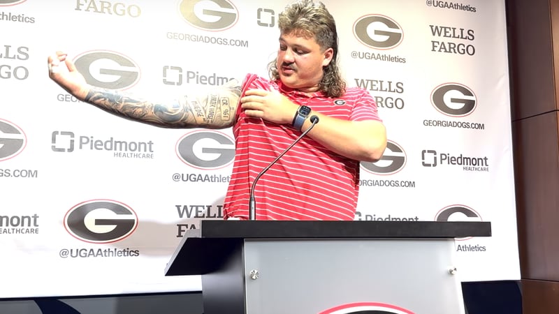 Tate Ratledge walks reporters through his new sleeve of tattoos during a news conference earlier this month.