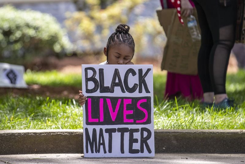 06/01/2020 - Atlanta, Georgia  - Corri Griffith, 5, takes a rest as she and her father Corey Griffith, who was close by, listen to demonstrators speak during a rally near the steps of Atlanta City Hall during the fourth day of protests in Atlanta, Monday, June 1, 2020. Corri and her father created the Black Lives Matter sign that she held during the rally. (ALYSSA POINTER / ALYSSA.POINTER@AJC.COM)