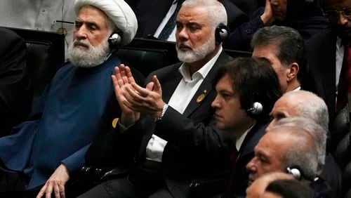 Hamas chief Ismail Haniyeh claps as newly-elected Iranian President Masoud Pezeshkian speaks while deputy leader of the Lebanese militant group Hezbollah, Sheikh Naim Kassem, left, sits during the swearing-in ceremony of Pezeshkian at the Iranian parliament, in Tehran, Iran, Tuesday, July 30, 2024. (AP Photo/Vahid Salemi)