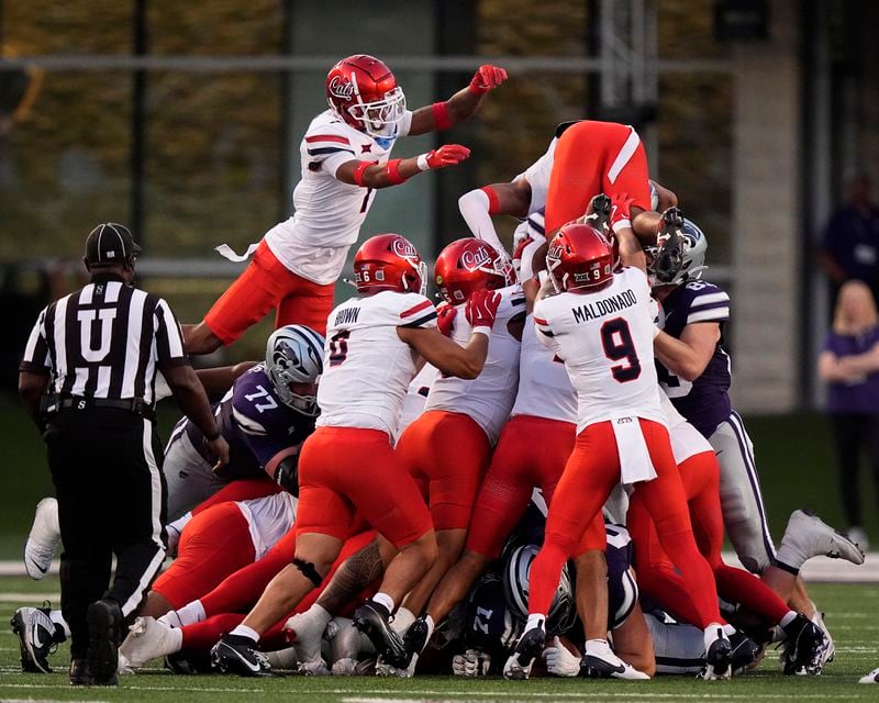 Arizona's defense tries unsuccessfully to stop a one yard run by Kansas State quarterback Avery Johnson for a first down during the first half of an NCAA college football game Friday, Sept. 13, 2024, in Manhattan, Kan. (AP Photo/Charlie Riedel)