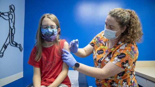 Licensed Practitioner Nurse Brittney Golden administers an Influenza vaccine to Railynn Hicks, 9, of Loganville, at Conyers Pediatrics in Conyers Wednesday (Alyssa Pointer/The Atlanta Journal-Constitution)
