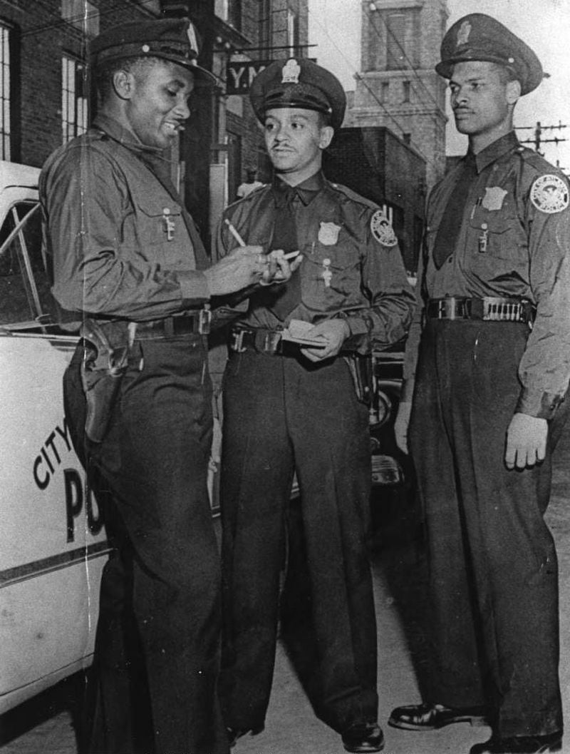 Atlanta police Officers Boxhead Turner (left), Clarence Perry (center), and Claude E. Mundy stand in front of the Butler Street YMCA in this 1950s photograph. Mundy was Atlanta's first African American police officer to be killed in the line of duty. He died on Jan. 5, 1961. In the 1950s, Black officers had to change clothes at the YMCA because they weren't allowed to do so at police headquarters. (AJC Archive at GSU Library AJCP284-001g)