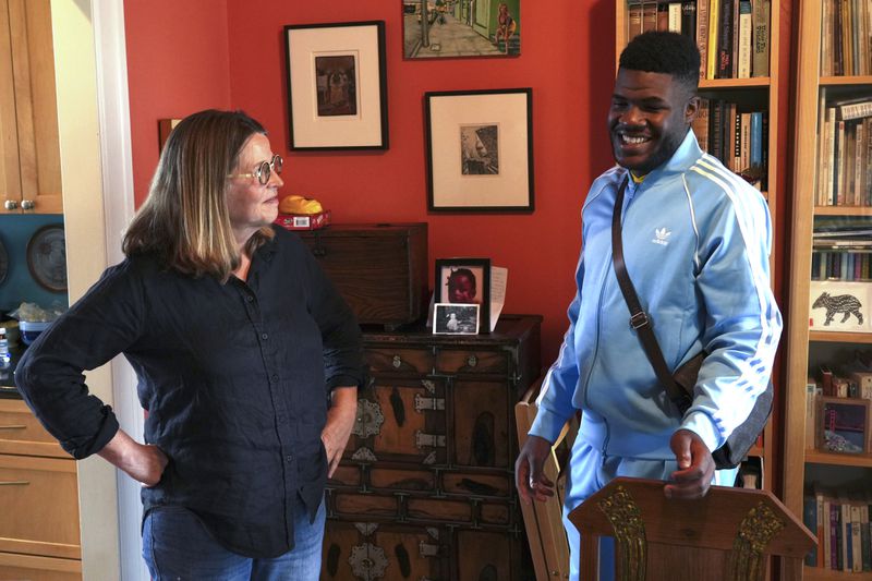 Cabrel Ngougou, a refugee from Cameroon, talks with his sponsor Lori Ostlund in her home in San Francisco Tuesday, Sept. 17, 2024. (AP Photo/Terry Chea)