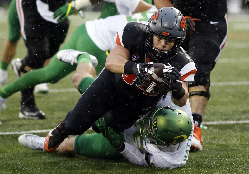 FILE - Oregon State running back Ryan Nall, top, dives over Oregon's Danny Mattingly for a touchdown in the second half an NCAA college football game in Corvallis, Ore., Nov. 26, 2016. (AP Photo/Timothy J. Gonzalez, File)