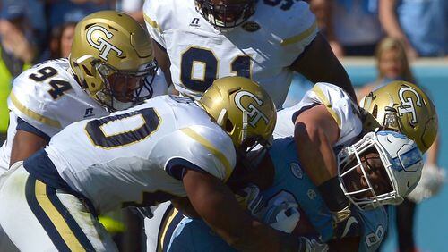 Anree Saint-Amour (94), Brandon Adams (90), Patrick Gamble (91) and Rod Rook-Chungong (41) of the Georgia Tech Yellow Jackets tackle T.J. Logan (8) of the North Carolina Tar Heels during the game at Kenan Stadium on November 5, 2016 in Chapel Hill, North Carolina. (Photo by Grant Halverson/Getty Images)