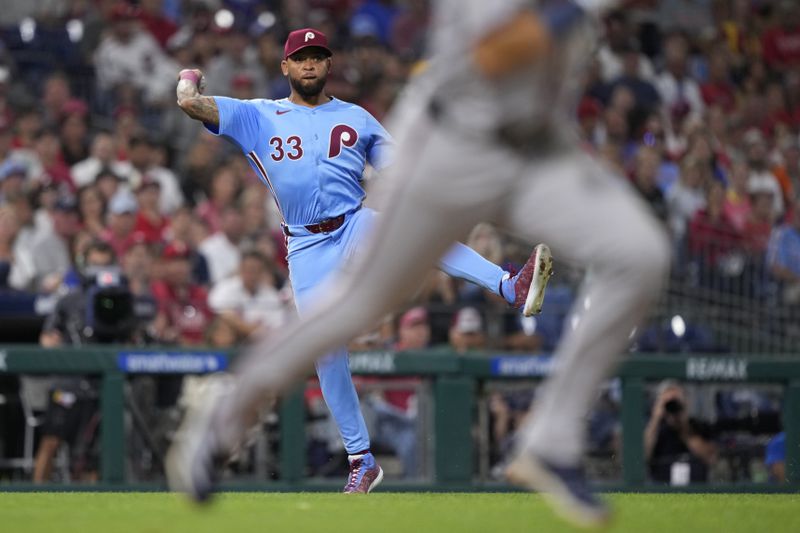 Philadelphia Phillies third baseman Edmundo Sosa, left, throws to first after fielding a bunt out by Atlanta Braves' Whit Merrifield during the fifth inning of a baseball game, Thursday, Aug. 29, 2024, in Philadelphia. (AP Photo/Matt Slocum)