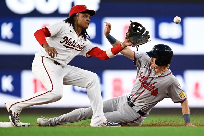 Washington Nationals shortstop CJ Abrams, left, fields a late throw as Atlanta Braves' Luke Williams steals second base during the third inning of a baseball game Tuesday, Sept. 10, 2024, in Washington. (AP Photo/John McDonnell)