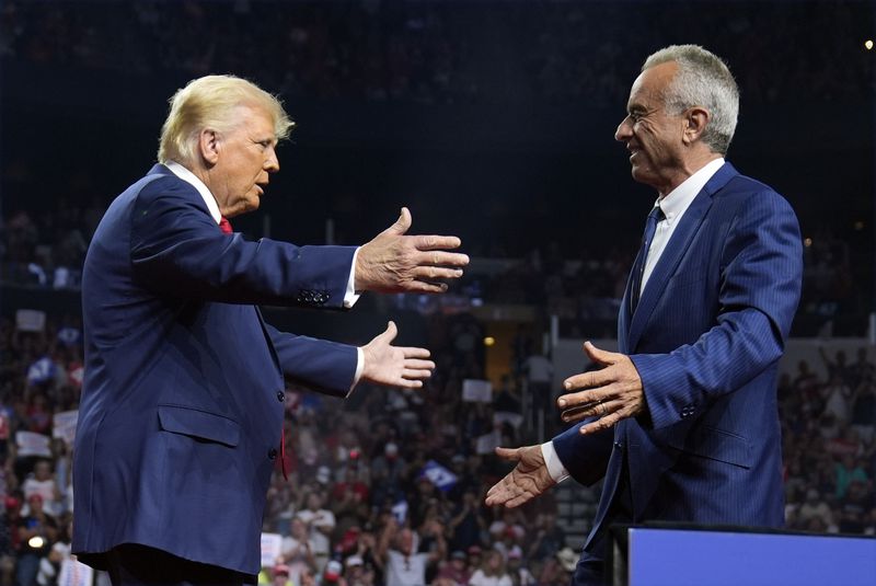 Republican presidential nominee former President Donald Trump greets Independent presidential candidate Robert F. Kennedy Jr. at a campaign rally at the Desert Diamond Arena, Friday, Aug. 23, 2024, in Glendale, Ariz. (AP Photo/Evan Vucci)