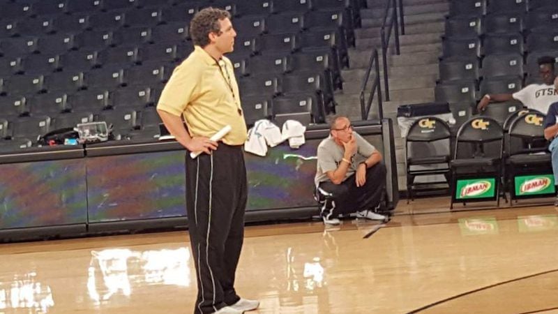 Ron Bell, kneeling, watches as Josh Pastner runs a drill during basketball practice at Georgia Tech in 2016. CONTRIBUTED