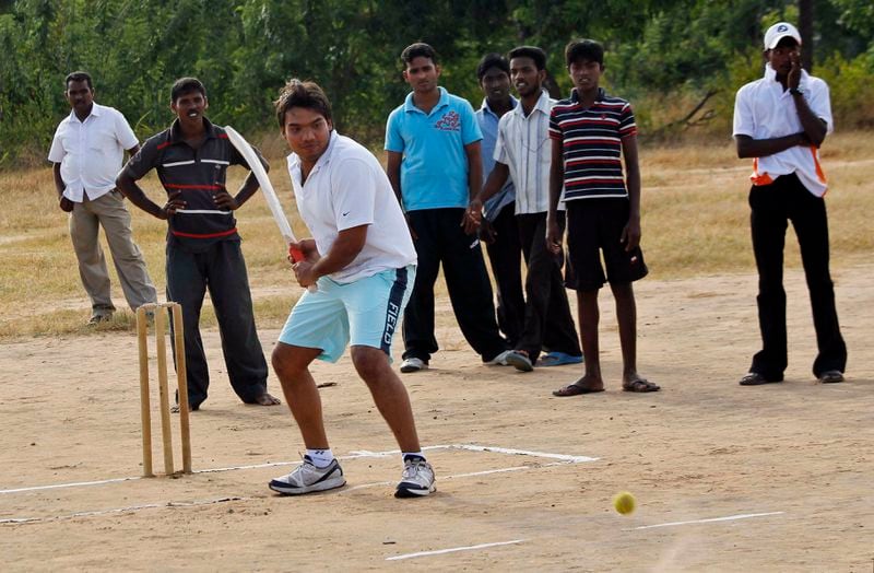 FILE- Namal Rajapaksa, center, Sri Lankan lawmaker and son of President Mahinda Rajapaksa, plays cricket with ethnic Tamil youth in Killinochchi, Sri Lanka, Thursday July 21, 2011. (AP Photo/ Eranga Jayawardena, File)