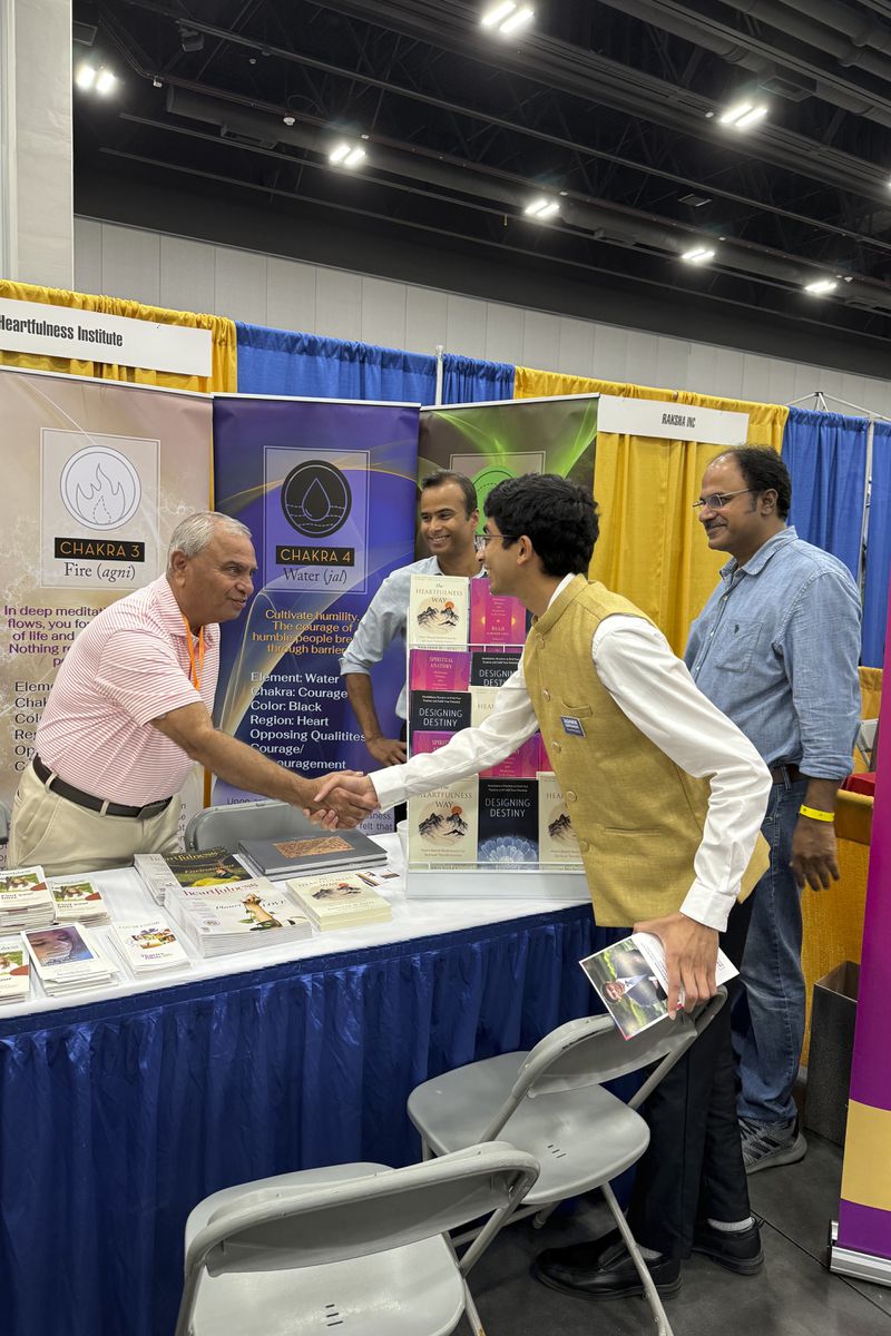 Democratic candidate Ashwin Ramaswami, right, shakes hands with voters at the Festival of India in Duluth, Ga., Saturday, Aug. 17, 2024. (AP Photo/Charlotte Kramon)