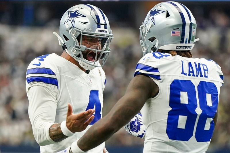 Dallas Cowboys quarterback Dak Prescott, left, reacts with wide receiver CeeDee Lamb after they connected for a long touchdown throw and pass against the New Orleans Saints during the first half of an NFL football game, Sunday, Sept. 15, 2024, in Arlington, Texas. (AP Photo/Jeffrey McWhorter)