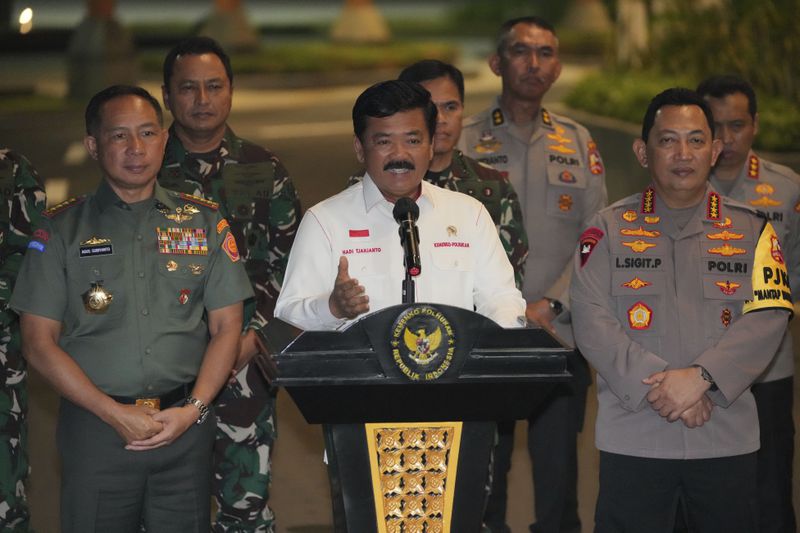 Indonesian Coordinating Minister for Political, Legal, and Security Affairs Hadi Tjahjanto, center, is flanked by Armed Forces Chief Gen. Agus Subiyanto, left, and National Police Chief Gen. Listyo Sigit Prabowo, right, as he speaks to the media after the arrival of Phillip Mark Mehrtens, a New Zealand pilot who was held hostage for more than a year by separatist rebels in the Papua region, at Halim Perdanakusuma Air Base in Jakarta, Indonesia, Saturday, Sept. 21, 2024. (AP Photo/Achmad Ibrahim)