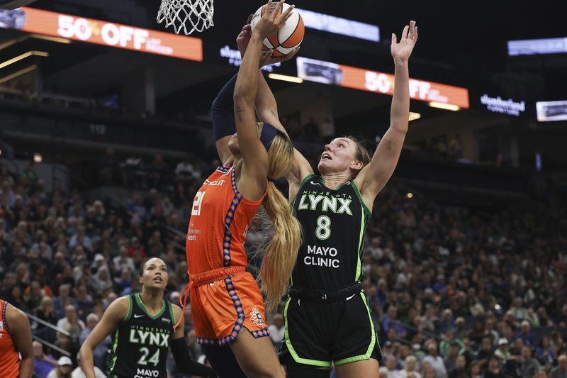 Minnesota Lynx forward Alanna Smith (8) blocks a shot by Connecticut Sun guard DiJonai Carrington (21) during the second half of Game 1 of a WNBA basketball semifinals series Sunday, Sept. 29, 2024, in Minneapolis. (AP Photo/Stacy Bengs)