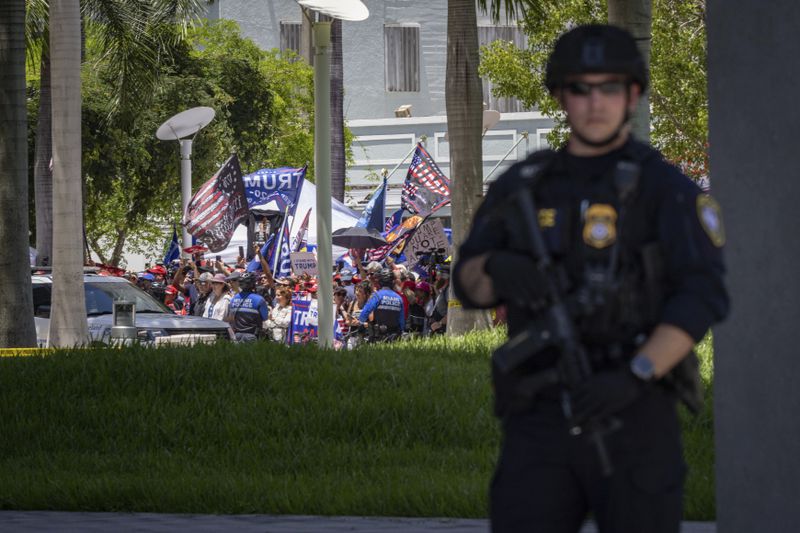 A law enforcement officer stands watch as former President Donald Trump arrives outside the Wilkie D. Ferguson Jr. U.S. Courthouse in Miami, June 13, 2023. Tuesday was the second time that Trump had called for protests at a court appearance, only to have his invitation receive a less-than-robust response. (Christian Monterrosa/The New York Times)
                      