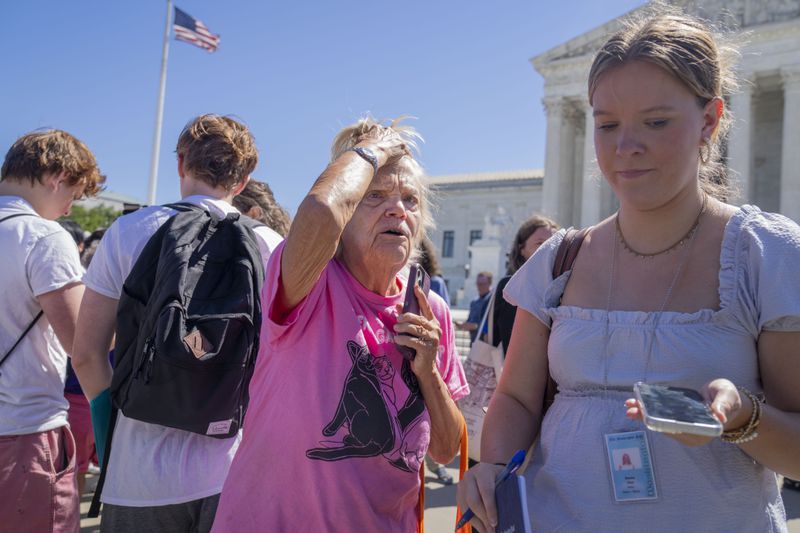 Celeste McCall, center, of Washington, reacts in confusion, Monday, July 1, 2024, outside the Supreme Court in Washington. "I'm confused I was told [Trump] has no immunity for unofficial acts," says McCall, "I don't even know what that means I'm beyond confused." (AP Photo/Jacquelyn Martin)