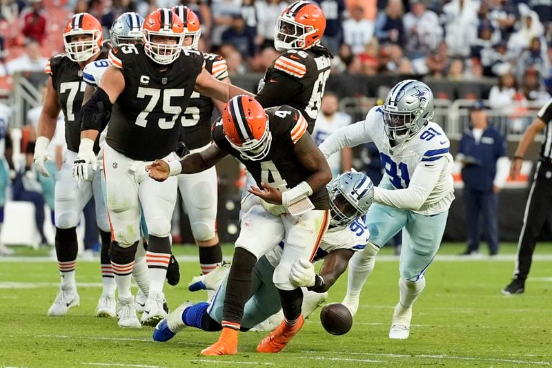 Cleveland Browns quarterback Deshaun Watson (4) has the ball stripped away by Dallas Cowboys defensive end DeMarcus Lawrence (90) in the second half of an NFL football game in Cleveland, Sunday, Sept. 8, 2024. (AP Photo/Sue Ogrocki)