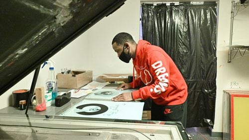 Reggie Boone works on color separation at Clothez Minded Custom Apparel in Norcross on Friday, March 19, 2021. Boone is currently a full-time graphic designer but started as an intern through Vowe, which sought a PPP federal relief loan to survive the pandemic. (Hyosub Shin / Hyosub.Shin@ajc.com)