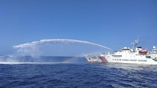 FILE - In this photo provided by the Philippine Coast Guard, a Chinese Coast Guard ship, right, uses its water cannons on a Philippine Bureau of Fisheries and Aquatic Resources (BFAR) vessel, as it approaches Scarborough Shoal in the disputed South China Sea, on Dec. 9, 2023. (Philippine Coast Guard via AP, File)