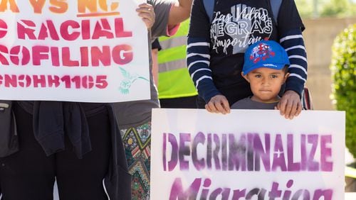 Emir Gonzalez (right), 4, is seen at a protest against HB 1105, which would would mandate that local law enforcement work more closely with ICE, at Liberty Plaza in front of the Georgia Captiol in May. (Arvin Temkar / AJC)