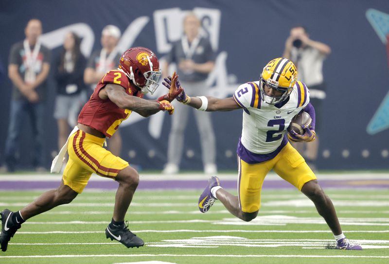 LSU wide receiver Kyren Lacy, right, tries to fend off a tackle by Southern California cornerback Jaylin Smith, left, during the first half of an NCAA college football game Sunday, Sept. 1, 2024, in Las Vegas. (AP Photo/Steve Marcus)