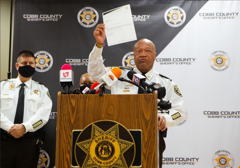 Cobb Sheriff Craig Owens holds up his letter ending Cobb County's participation in the Federal 287(G) Program during a press conference on Tuesday, January 19, 2021, at the Cobb County Sheriff's Office in Marietta, Georgia. The Federal 287(G) Program was a collaboration between the sheriff's department and Immigration and Customs Enforcement (ICE).  CHRISTINA MATACOTTA FOR THE ATLANTA JOURNAL-CONSTITUTION