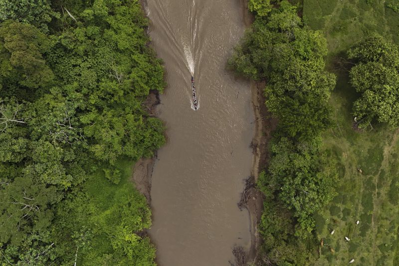 A boat takes migrants to Lajas Blanca, Panama, Thursday, Sept. 26, 2024, after they trekked across the Darien Gap from Colombia in hopes of reaching the U.S. (AP Photo/Matias Delacroix)