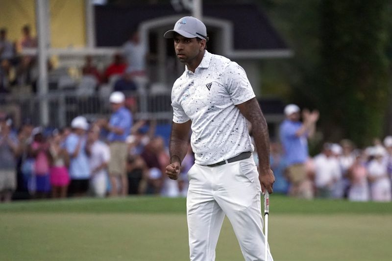 Aaron Rai, of England, celebrates on the 18th hole after winning the Wyndham Championship golf tournament in Greensboro, N.C., Sunday, Aug. 11, 2024. (AP Photo/Chuck Burton)