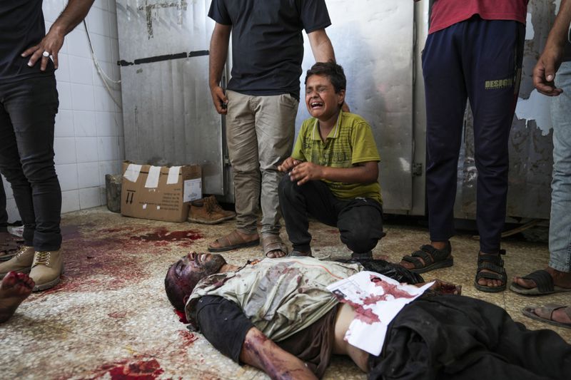 Palestinian boy cries over a relative killed in the Israeli bombardment of the Gaza Strip at a morgue l in Deir al Balah on Tuesday, June 4, 2024. (AP Photo/Abdel Kareem Hana)