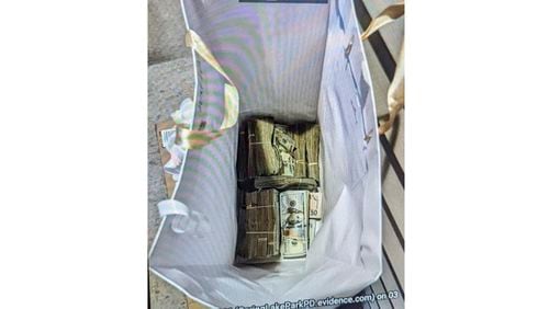 FILE - This photo supplied by the U.S. Attorney's Office for Minnesota shows cash from a bag that was left at the home of a juror in a massive fraud case, June 2, 2024, outside Minneapolis, Minn. Two of five people charged with conspiring to bribe the juror with a bag of $120,000 in cash in exchange for the acquittal of defendants in one of the country’s largest COVID-19-related fraud cases pleaded not guilty Wednesday, July 3, 2024. (U.S. Attorney's Office for Minnesota via AP, File)