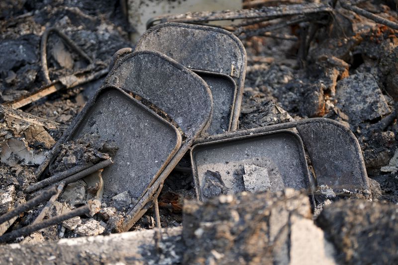 Chairs are stacked among the ruins in the aftermath of the Bridge Fire, Thursday, Sept. 12, 2024, in Wrightwood, Calif. (AP Photo/Eric Thayer)