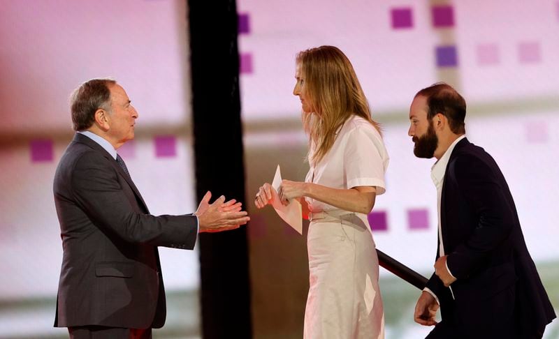 NHL Commissioner Gary Bettman, left, welcomes singer Celine Dion onto the stage during the first round of the NHL hockey draft Friday, June 28, 2024, in Las Vegas. Dion helped announce the selection of Ivan Demidov by the Montreal Canadiens. (AP Photo/Steve Marcus)