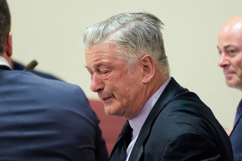 Actor Alec Baldwin, center, reacts as he sits between his attorneys Alex Spiro, left, and Luke Nikas after the judge threw out the involuntary manslaughter case for the 2021 fatal shooting of cinematographer Halyna Hutchins during filming of the Western movie "Rust," Friday, July 12, 2024, in Santa Fe, N.M. (Ramsay de Give/Pool Photo via AP)